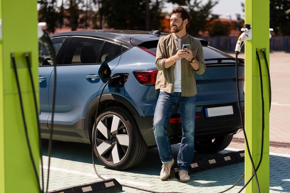 Electric cars in Iceland: what to know Young man waiting for this EV vehicle to fully charge