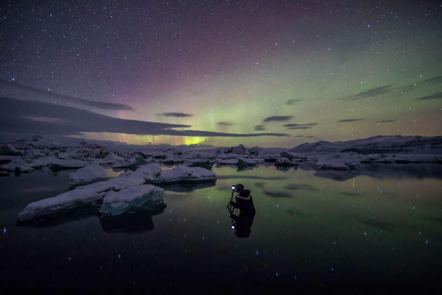 photo tour in Iceland, photographer taking a picture of the aurora borealis
