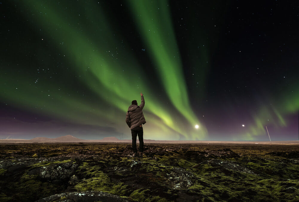young boy hunting for the northern lights in Iceland