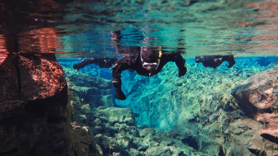 tourist diving in silfra where the tectonic plates meet in the map of Iceland