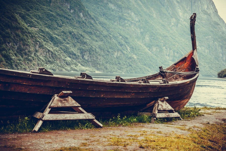 Replica of a viking ship by the fjords coast line