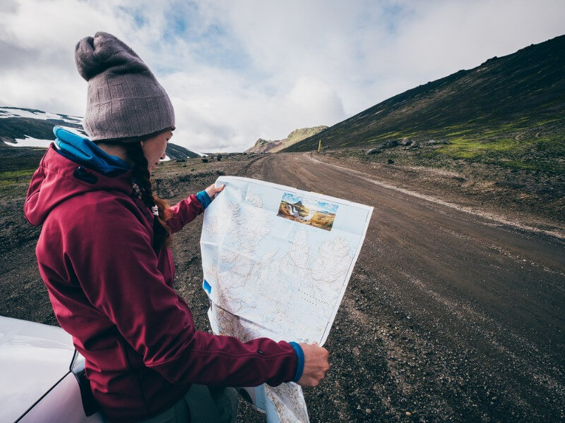 women traveling solo around Iceland with a map in her hands
