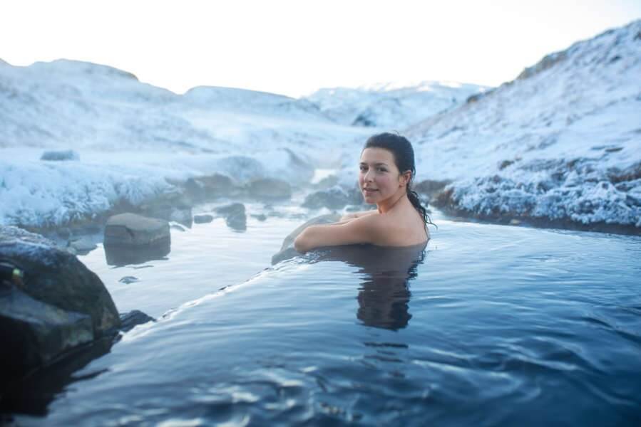 woman bathing in hot spring in Iceland with majestic views