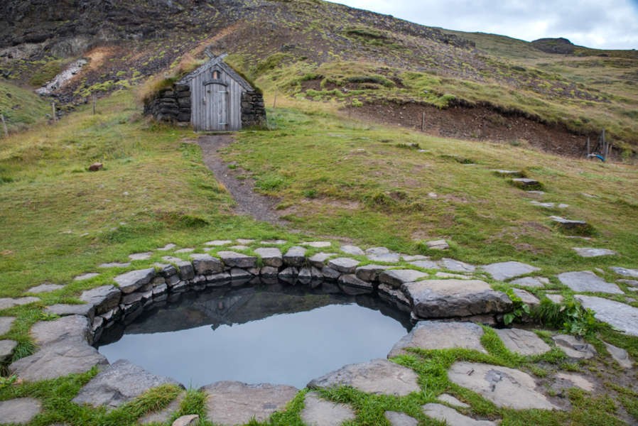 hot spring close to a typical Icelandic turf house