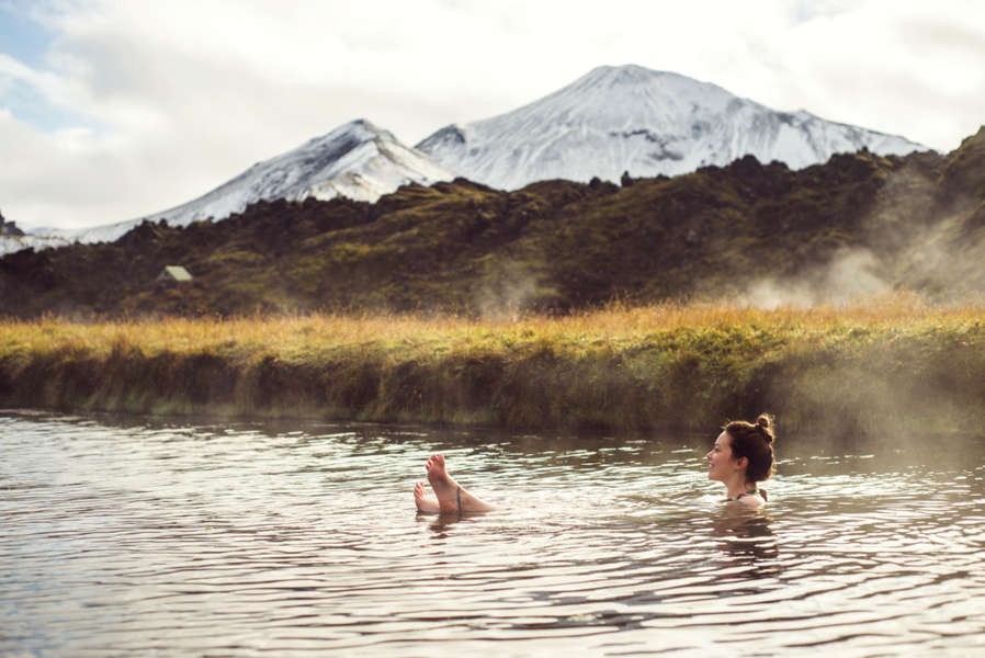 young woman bathing in Landmannalaugars hot springs