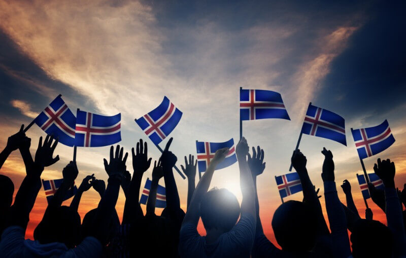 Crowd holding flags of Iceland - Iceland demographics