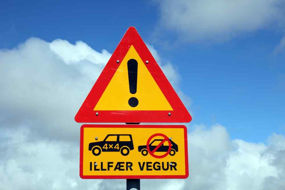 The importance of renting a 4x4 in Iceland Close-up of an Icelandic road warning sign indicating a rough road for 4x4 vehicles only.