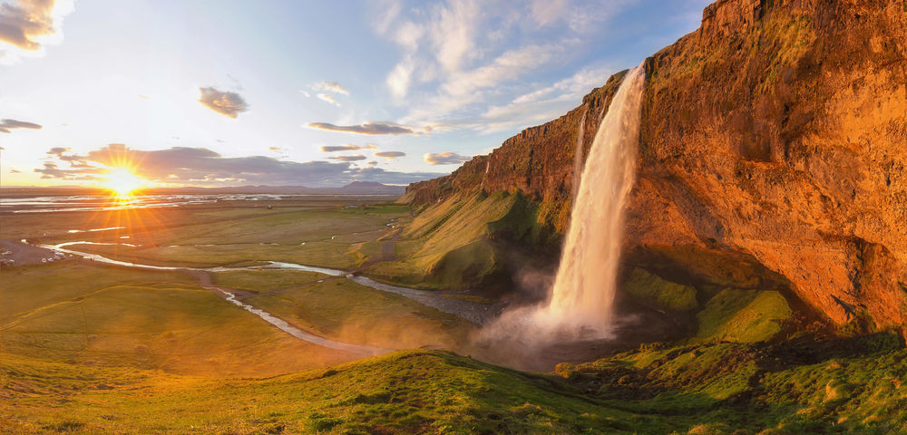 Midnight sun in Southern Iceland by a waterfall