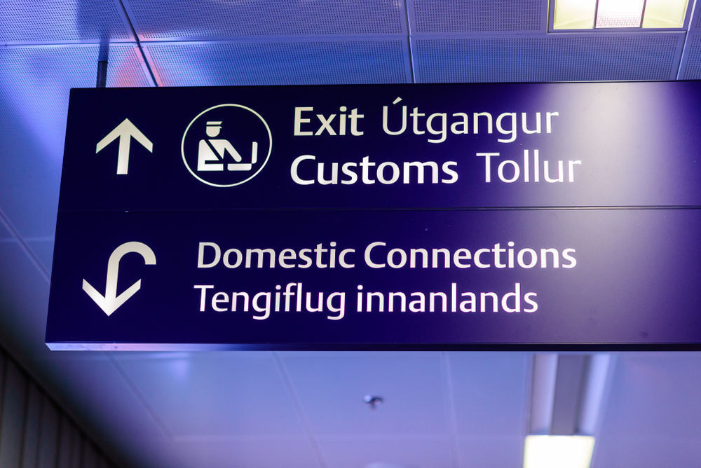 Airport sign showing the way to customs and domestic connections- flights to Iceland