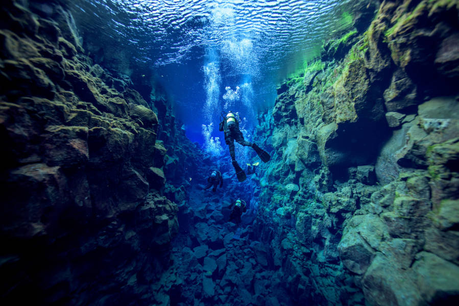 Divers swimming in the Silfra Fissure in Iceland
