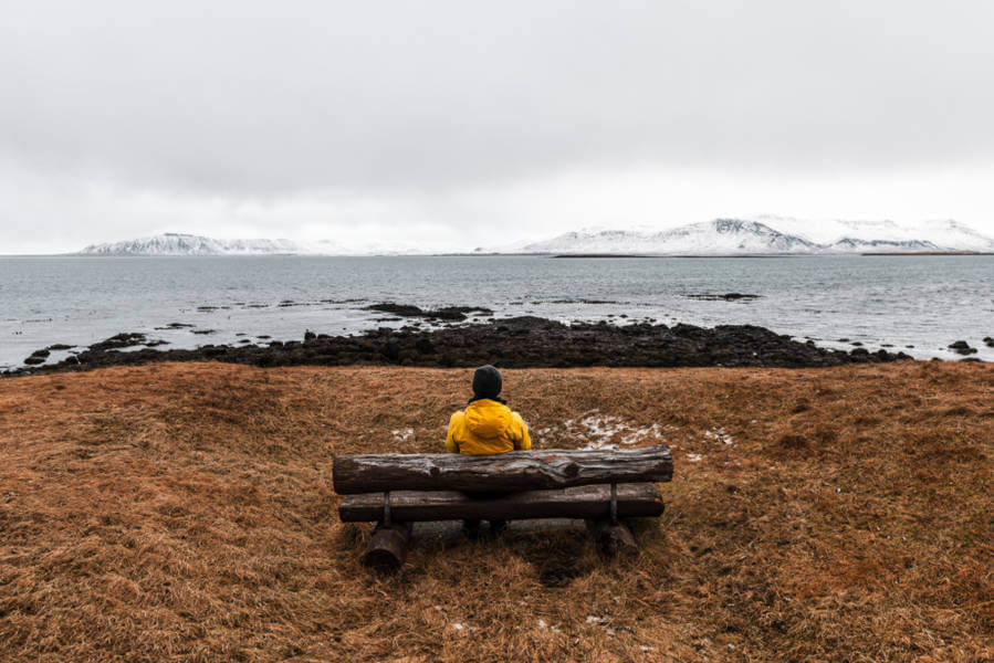 man sitting on a bench in a very remoted and barely visited place in Iceland