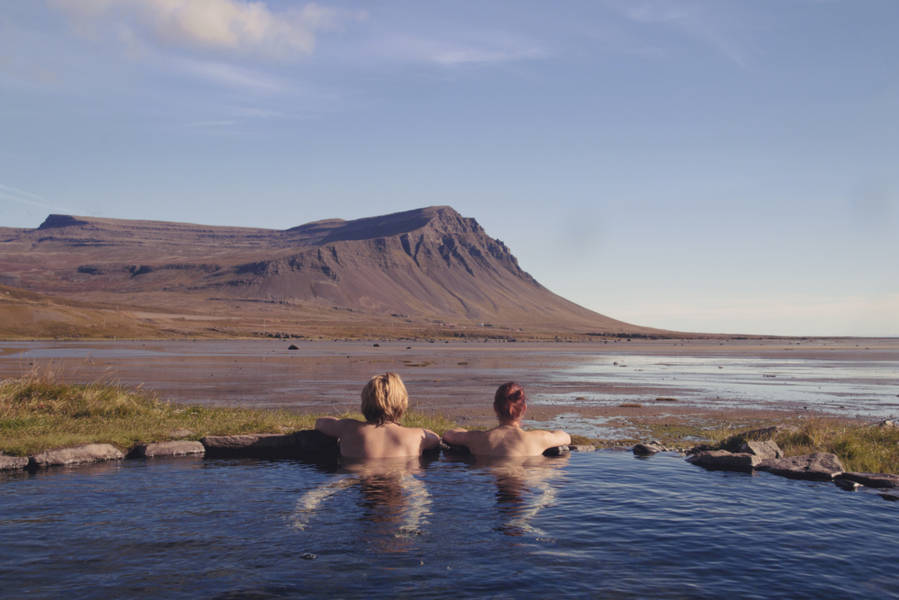 Two tourist in a hot spring located in one of the least visited places in Iceland
