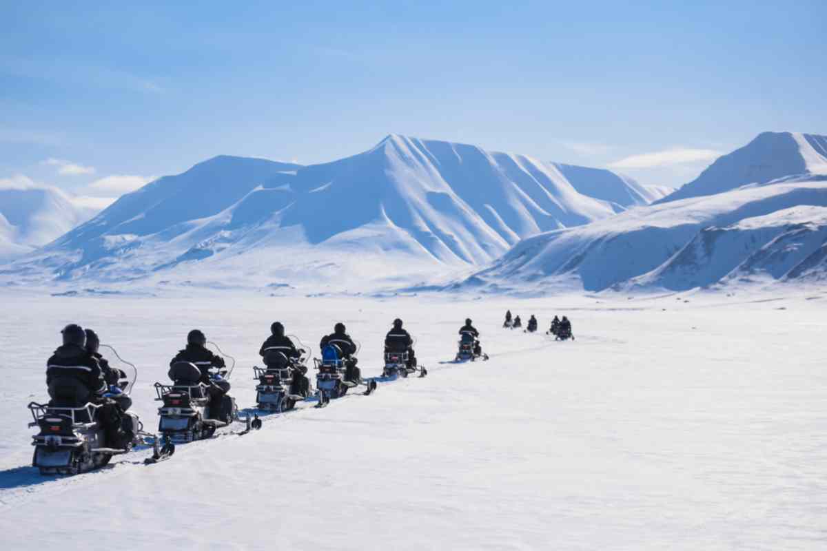 Row of snowmobilers heading to the mountains