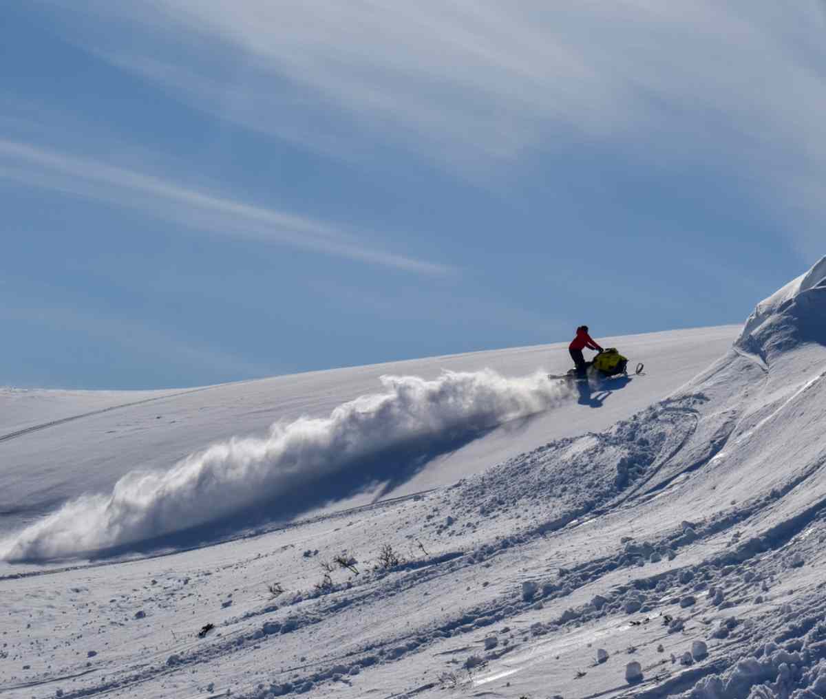 Snomobile driver going up a slope