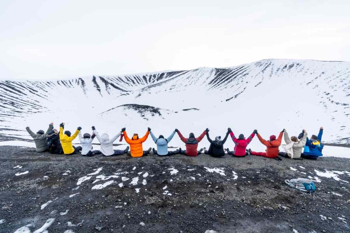 Group of visitors sitting on the edge of Hverfell volcano