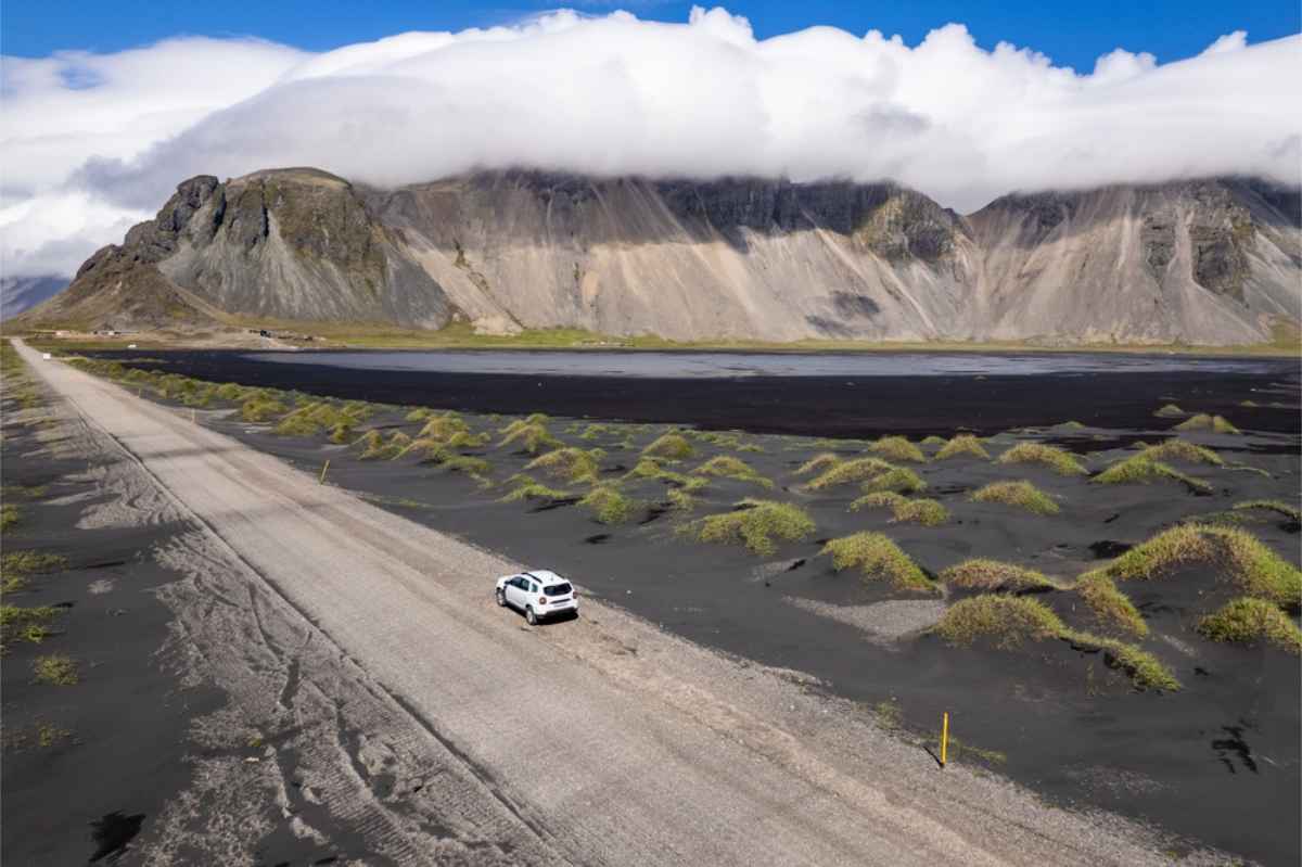 White SUV parked near Vestrahorn mountain in Iceland