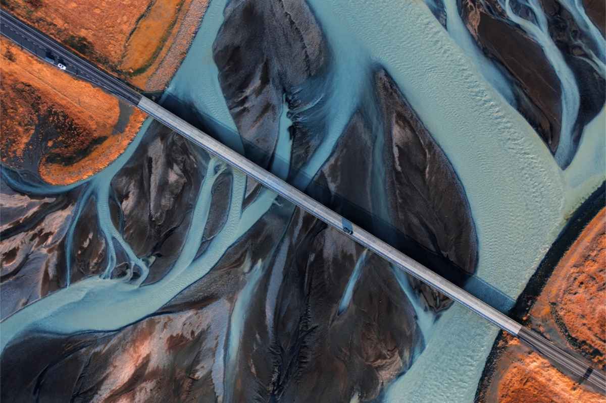 Impressive drone shot of a road in Iceland with glacier rivers running below it