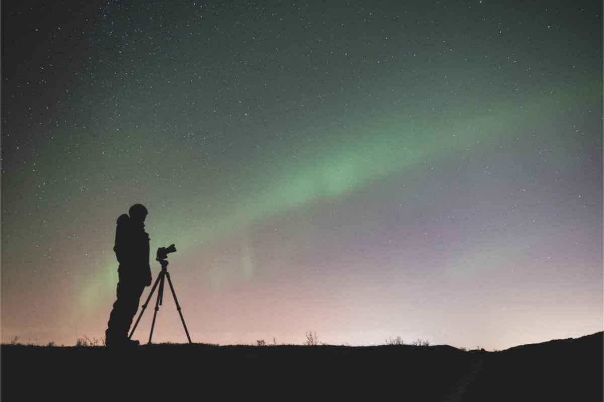 Photographer watching the Northern Lights shining in Iceland's sky