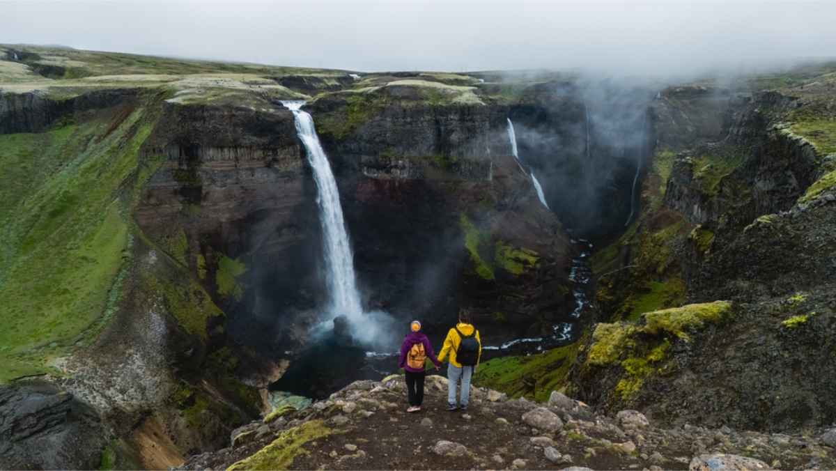 Couple standing in front of Haifoss waterfall