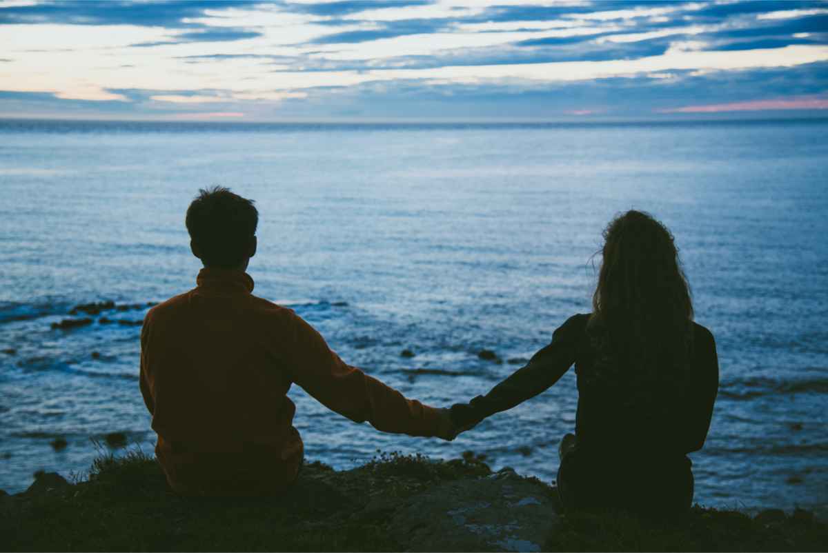 Couple holding hands while overlooking at the atlantic ocean