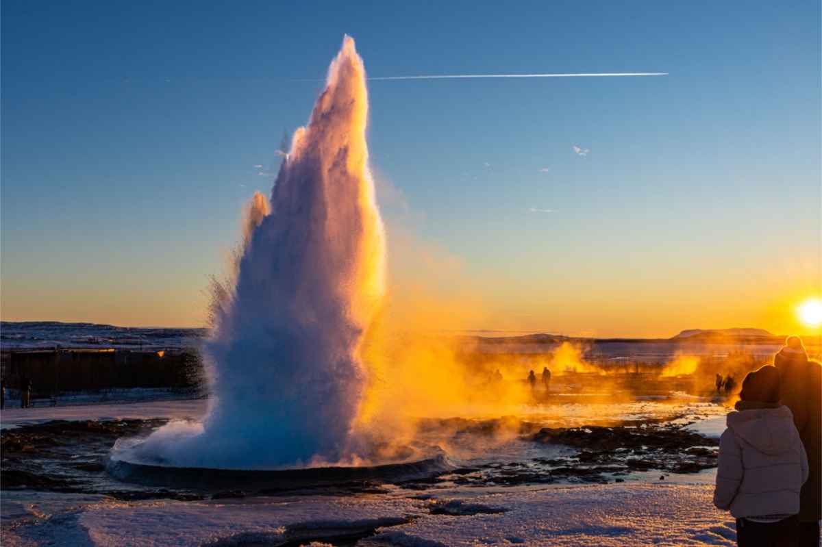 Geysir gushing water into the air during the golden hour