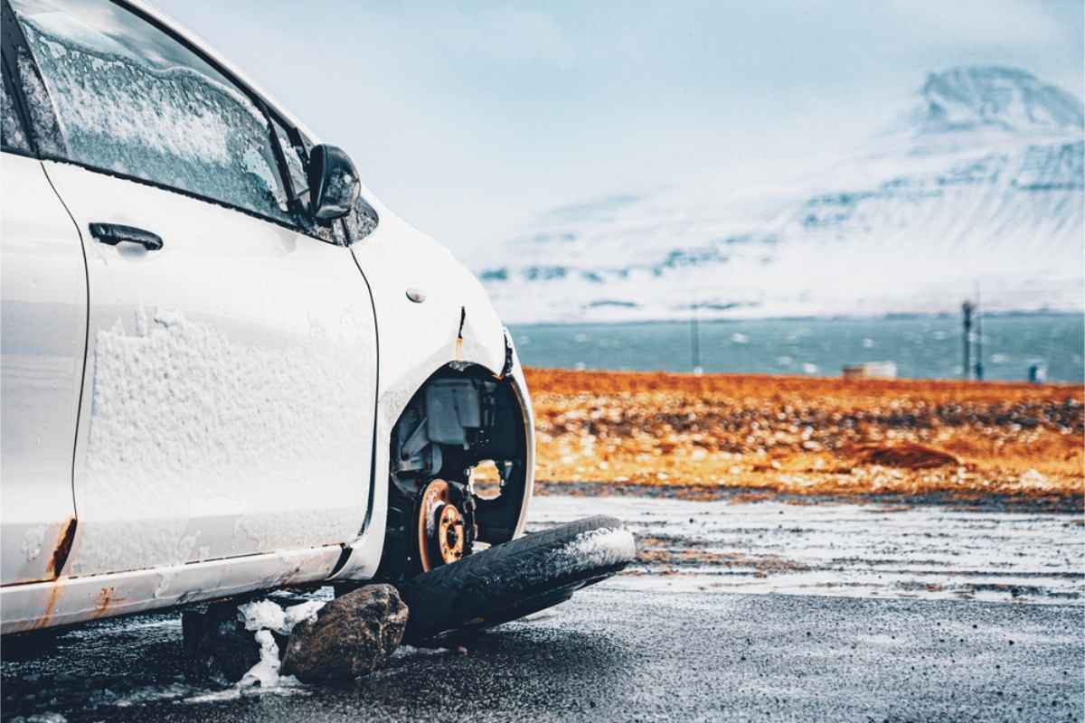 Damaged vehicle after and accident, covered in snow and with a broken wheel
