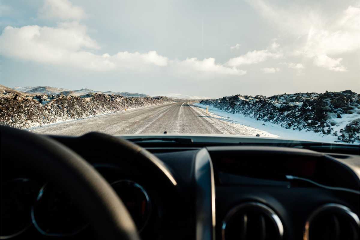 View of a snowed road from the driver's side