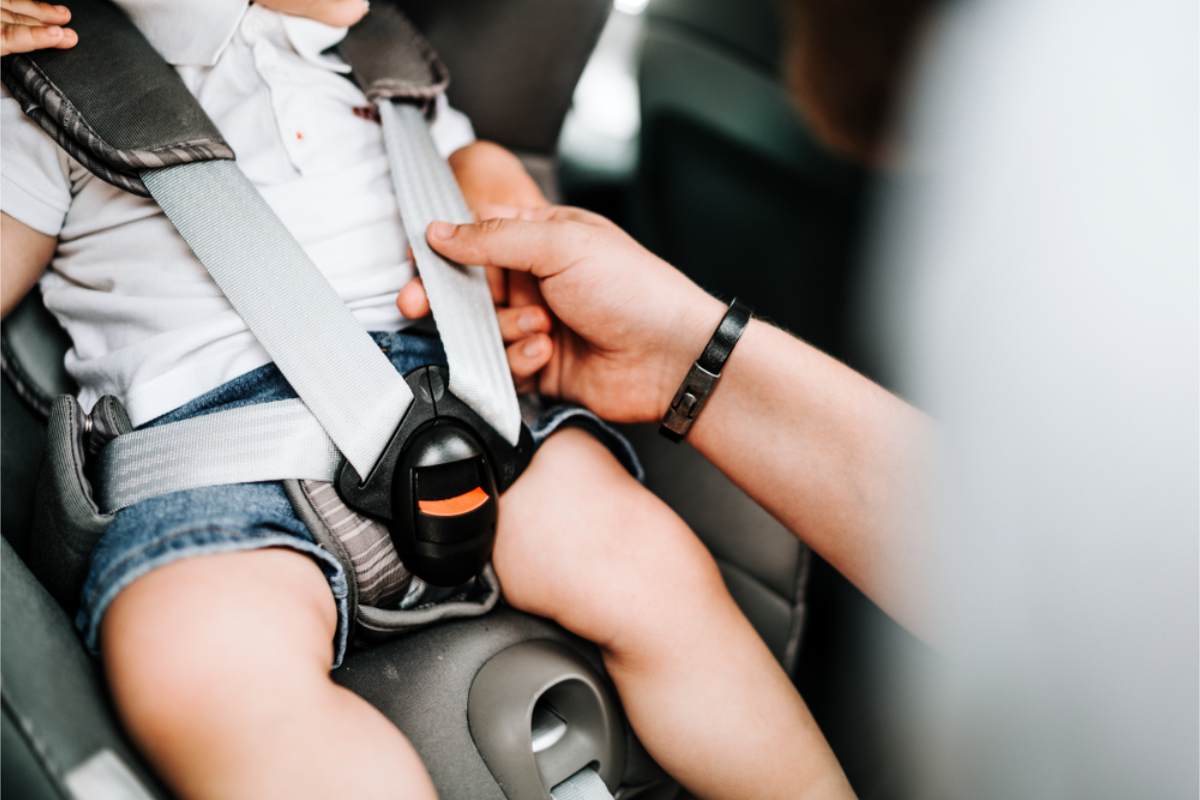 Isländische Kindersitzvorschriften für Mietwagen Kleinkind in seinem Kindersitz wird angeschnallt
