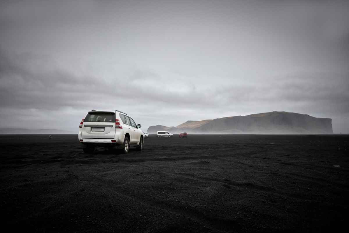 Mietwagen am schwarzen Sandstrand in Island