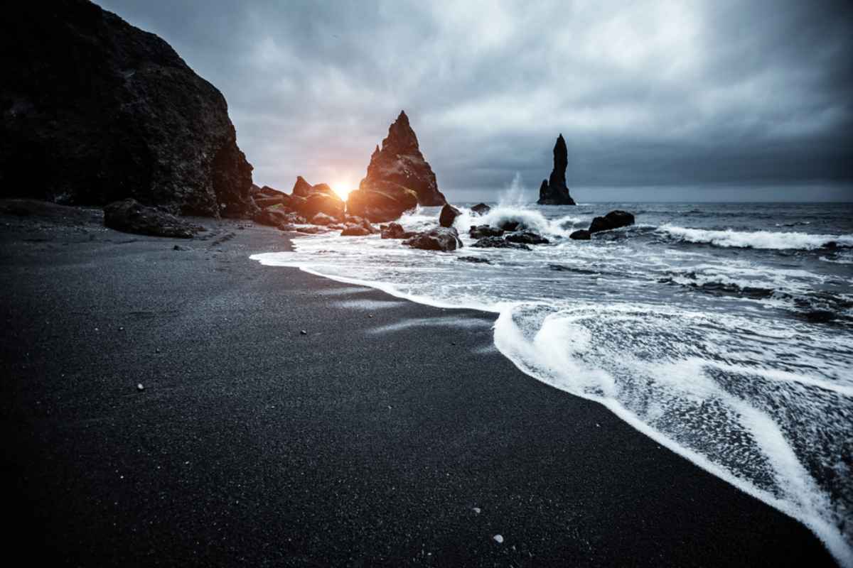 Reynisfjara Strand mit Felsformationen im Hintergrund