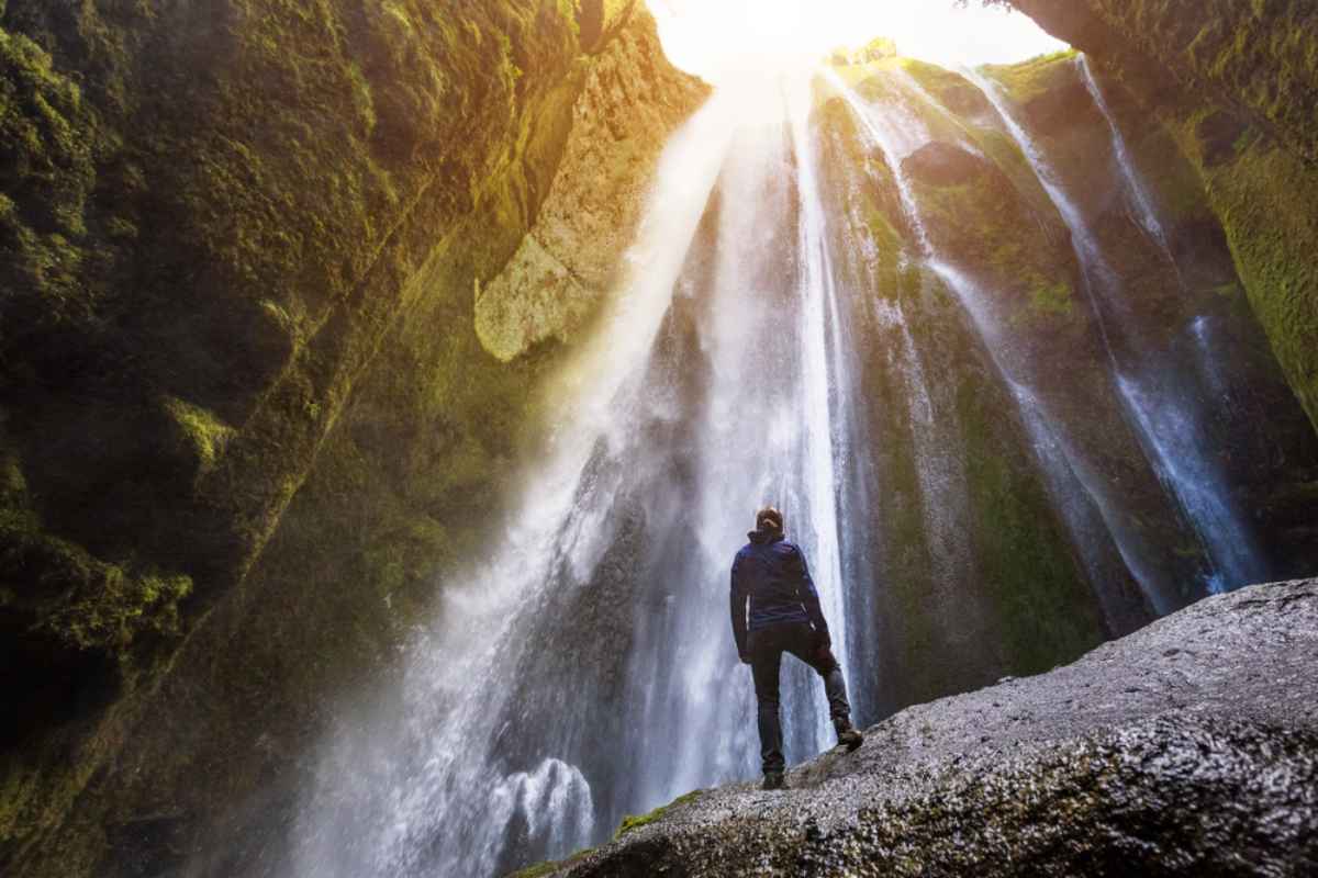 Beste Schuhe für Island je nach Aktivität Wanderschuhtruppe, die in der isländischen Wildnis einen wunderschönen Wasserfall betrachtet