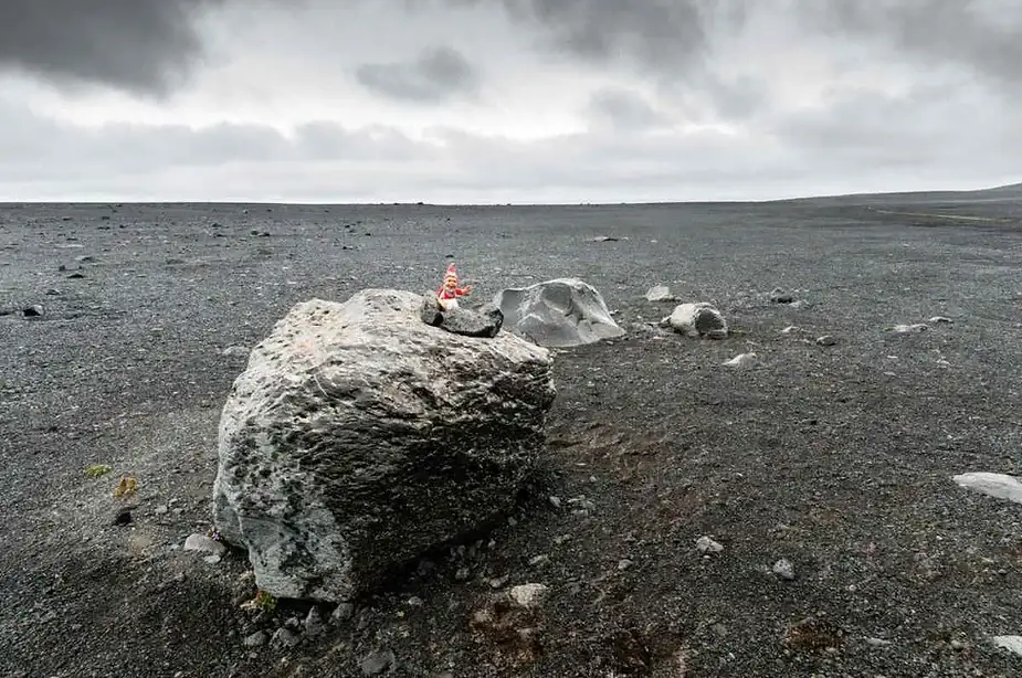 Elfo sentado en una enorme roca en las Tierras Altas de Islandia