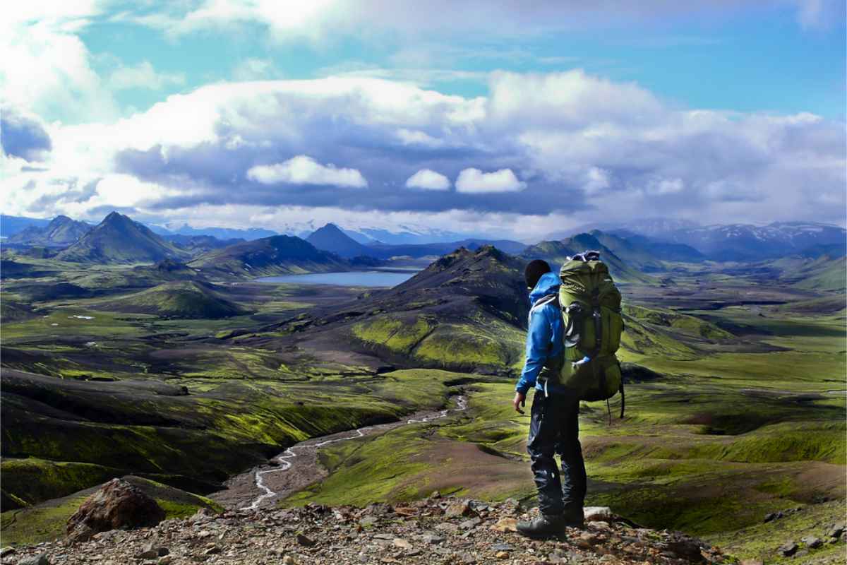 Qué ponerse en Islandia en agosto Excursionista contemplando los paisajes de Islandia con la ropa y el equipo adecuados