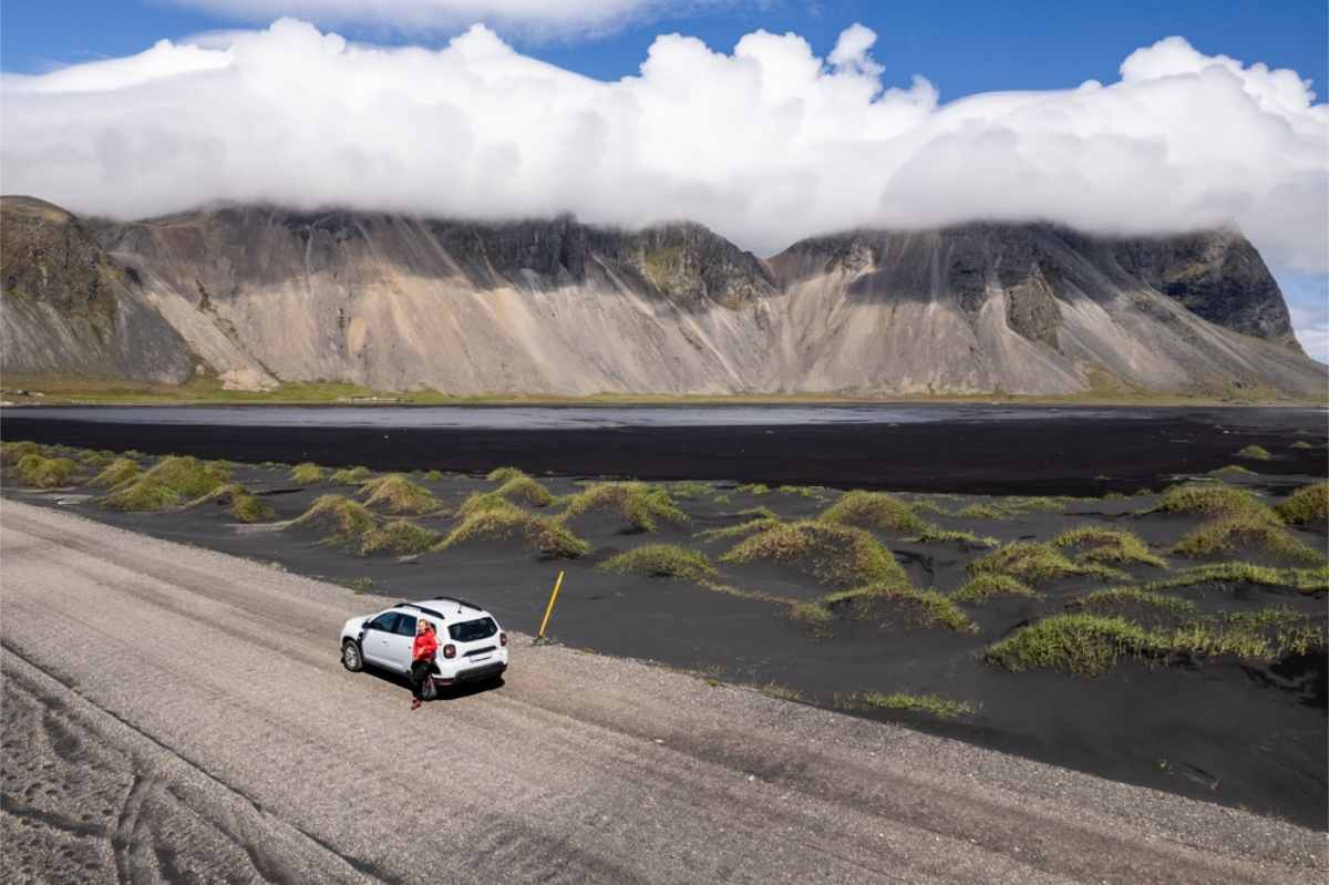 Clima y condiciones de las carreteras en septiembre Dacia duster blanco aparcado cerca de la montaña Vestrahorn