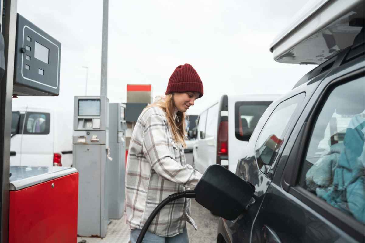 Precios del combustible y tipos de combustible en Islandia Mujer repostando su coche en una gasolinera islandesa
