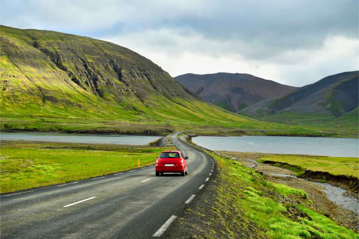 Estaciones y condiciones meteorológicas en el verano de Islandia Coche 2WD rojo circulando por la carretera circular de Islandia durante el verano
