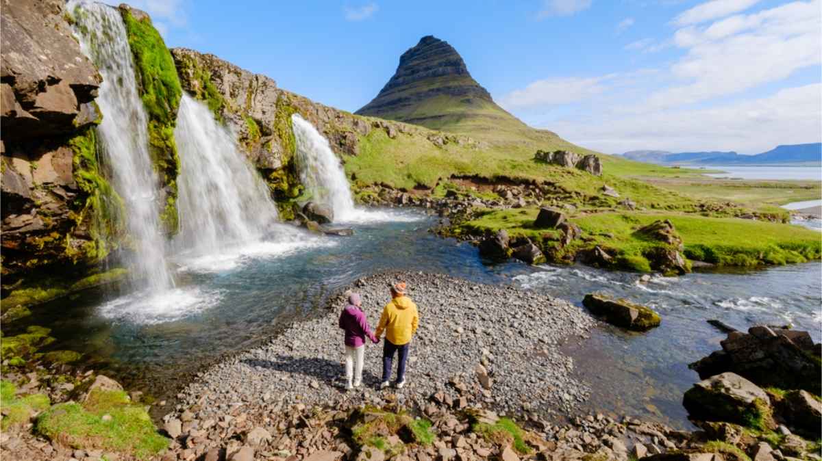 Kirkjufell, península de Snæfellsnes Pareja cogidos de la mano junto a Kirkjufell