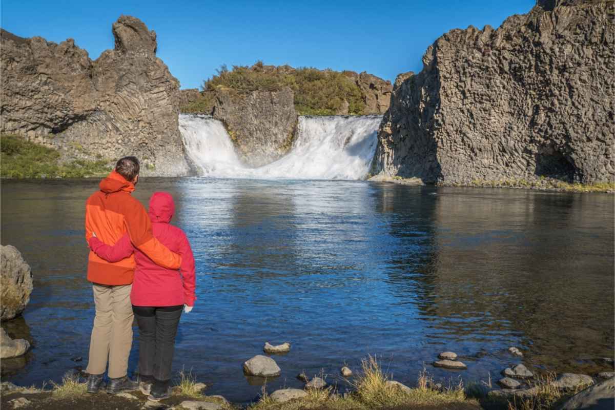 Hjálparfoss, sur de Islandia Pareja abrazándose en Hjálparfoss
