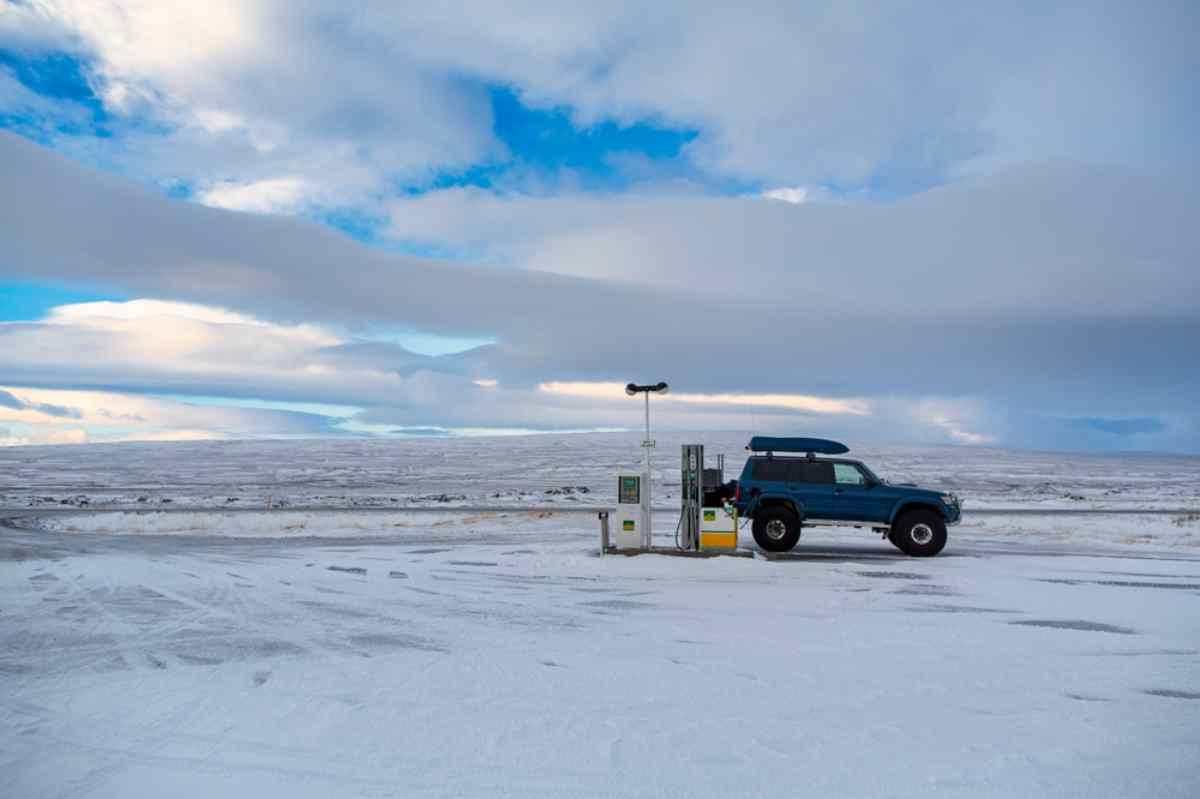 Coche repostando en una gasolinera remota rodeada de nieve en Islandia.
