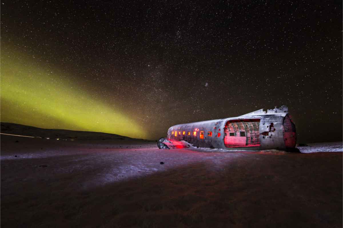 Restos de un avión en Islandia con las auroras boreales danzando arriba