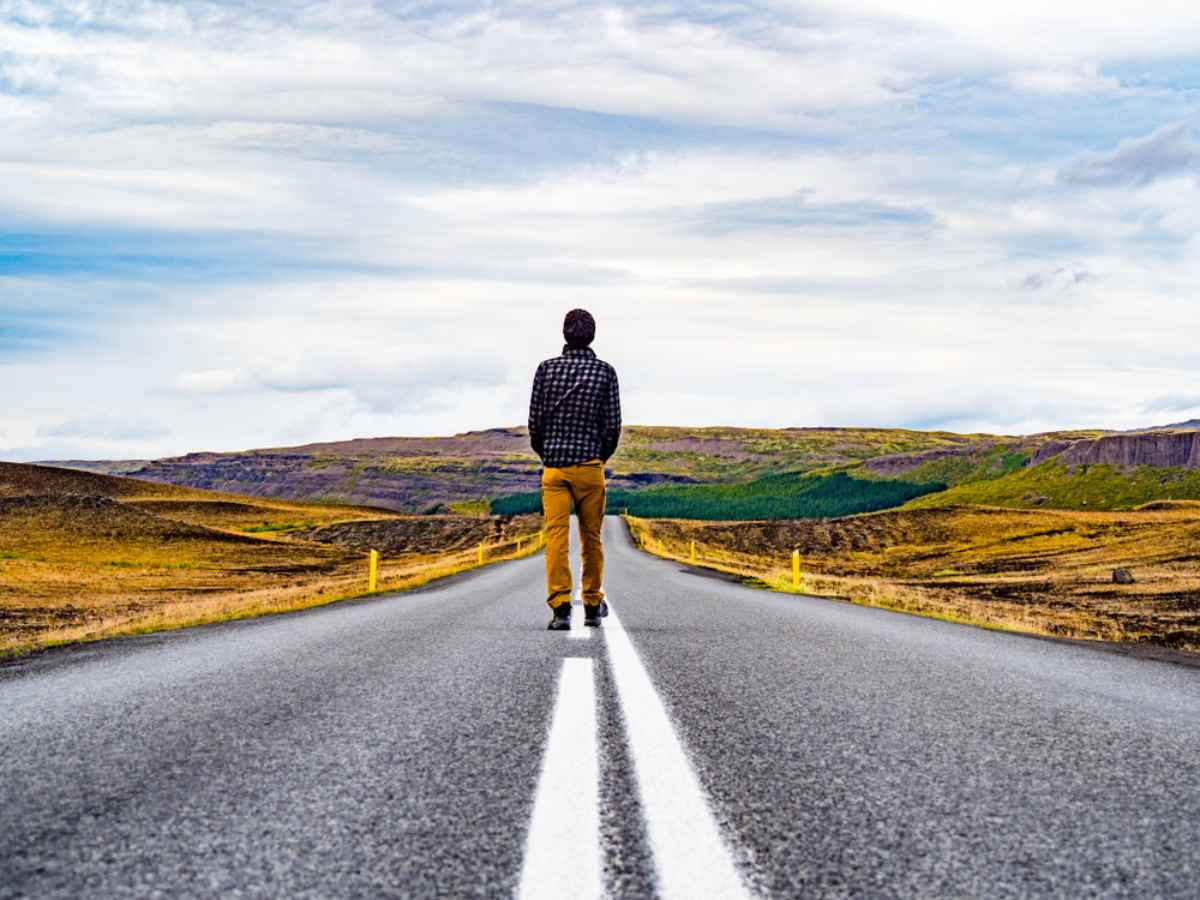 Turista caminando por una carretera solitaria
