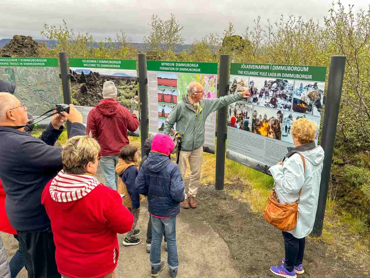 Guía explicando los campos de lava de Dimmuborgir a un grupo en el norte de Islandia.