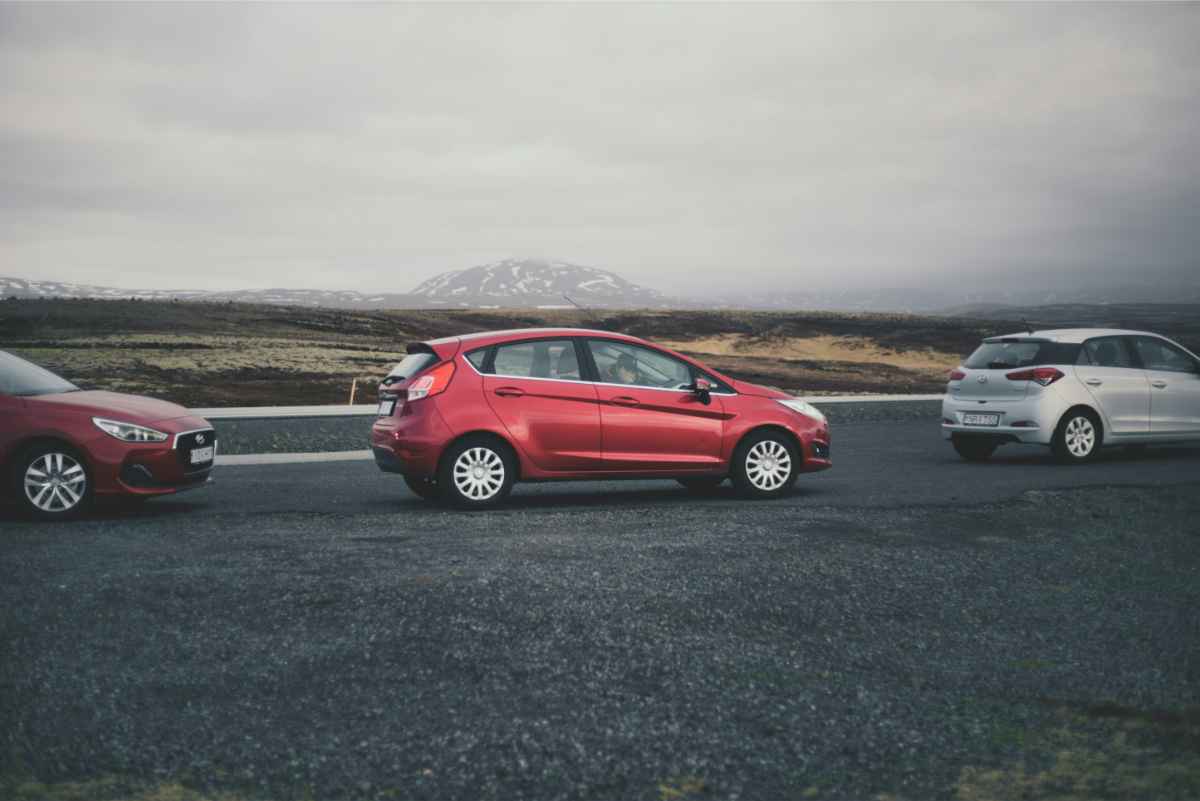 Voiture citadine compacte rouge gar&eacute;e en Islande