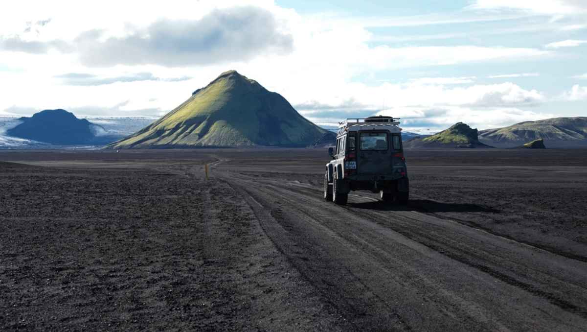 V&eacute;hicule 4&times;4 au milieu des impressionnantes Highlands islandaises avec paysage volcanique