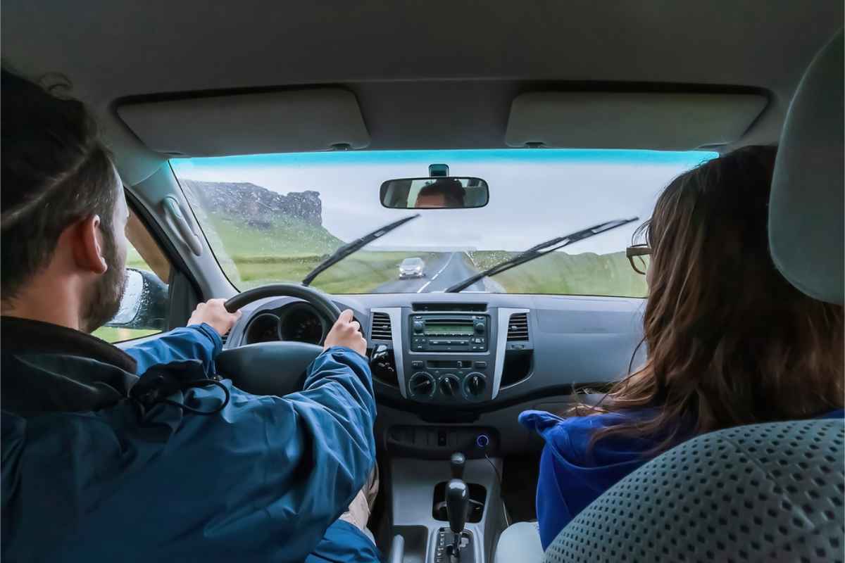 Vue de la Ring Road islandaise depuis l&rsquo;int&eacute;rieur d&rsquo;une voiture de location tandis qu&rsquo;un homme conduit