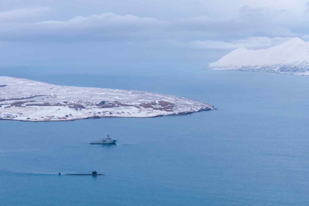 Navire de la garde-c&ocirc;tes et un sous-marin man&oelig;uvrant dans un fjord islandais en hiver.