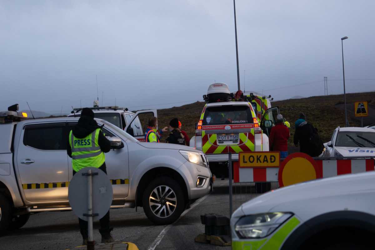 Chiusure stradali in Islanda Veicoli di emergenza e barriera stradale che bloccano una strada chiusa in Islanda con poca luce e maltempo