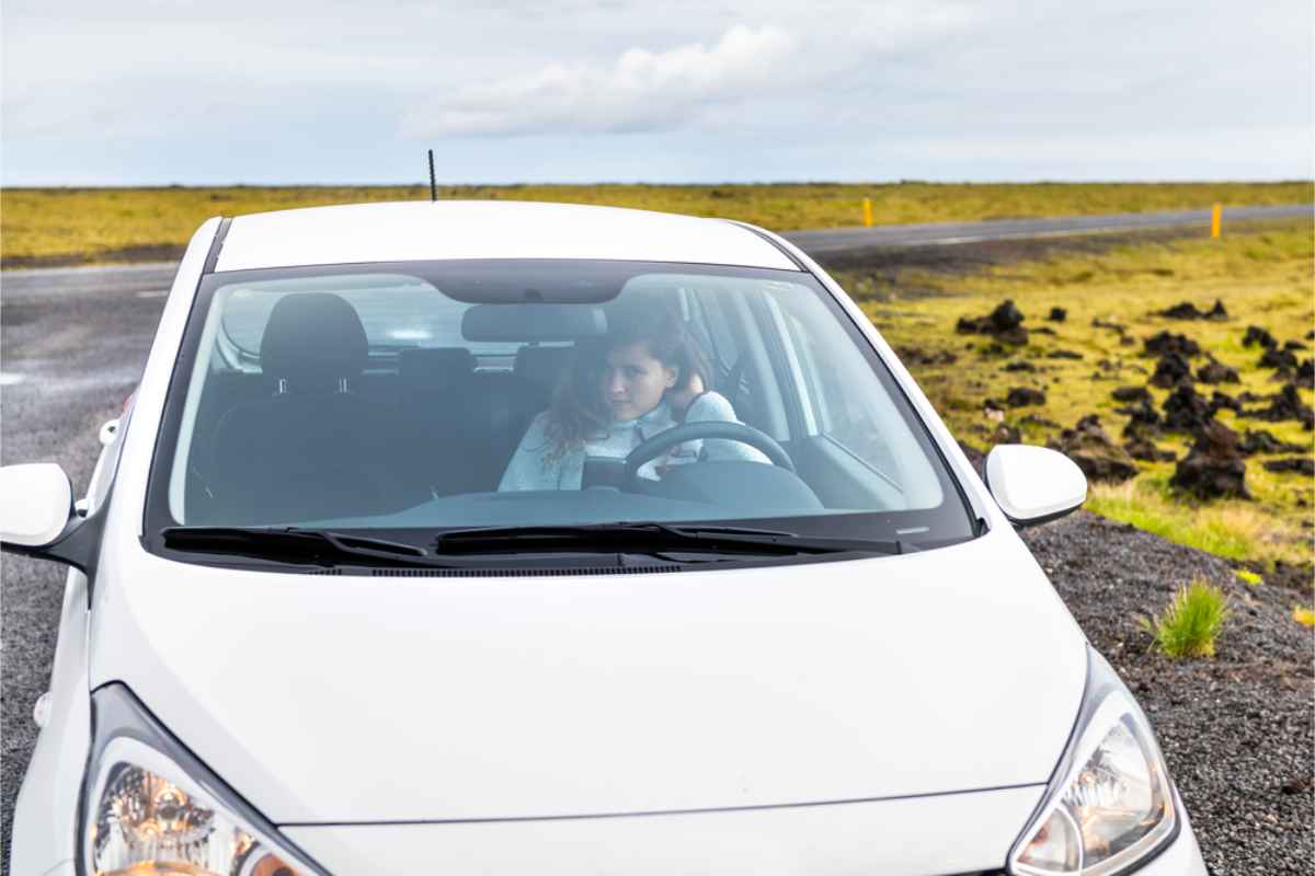 Migliori auto per guidare in Islanda durante l’estate Donna seduta nella sua city car compatta mentre guida sulle strade principali dell’Islanda