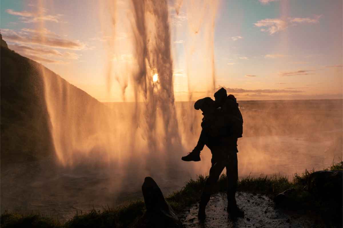 Cascata Seljalandsfoss nel sud dell’Islanda Sagoma di una coppia che si bacia dietro Seljalandsfoss