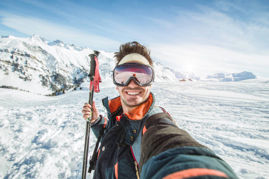 men taking a selfie in a snow-covered mountain and ski gear